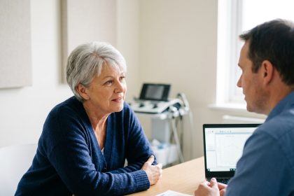 Femme de 60 ans lors d'une consultation audiologique dans une clinique moderne, en discussion attentive avec un audiologiste
