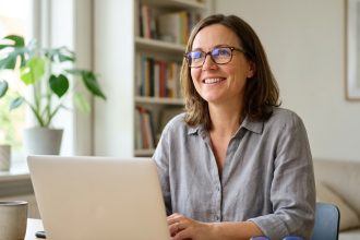 Femme portant des lunettes de vue à son bureau avec une deuxième paire posée à côté, illustrant l'utilité d'une seconde paire de lunettes au quotidien