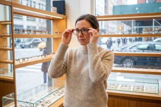 Femme essayant des lunettes dans une boutique d'optique