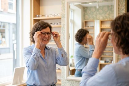 Femme souriante essayant des lunettes dans une boutique locale