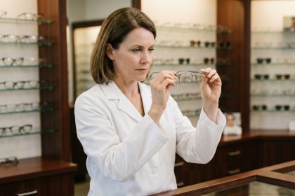Opticienne experte examinant une monture en titane haut de gamme dans une boutique d'optique luxueuse